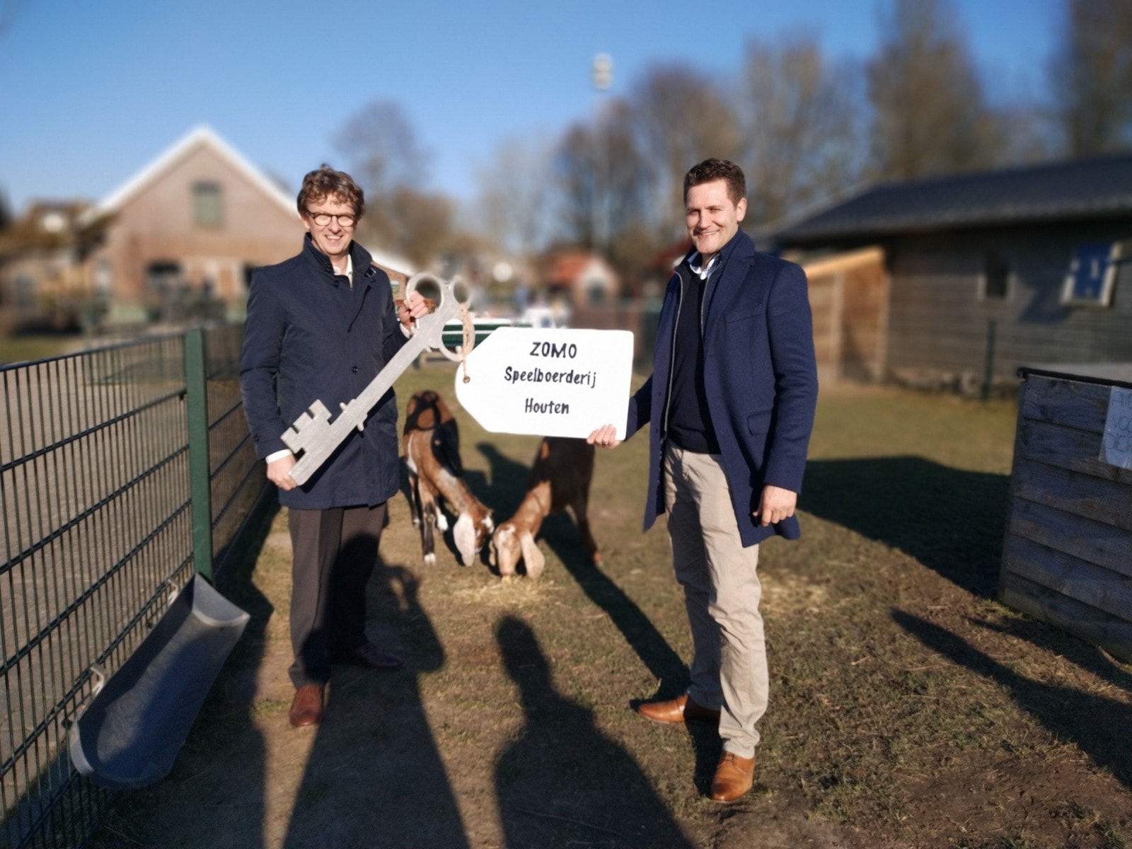 Wethouder Jan Overweg overhandigt de sleutel van de speelboerderij aan Merijn Vos, directeur ZOMO Dagbesteding